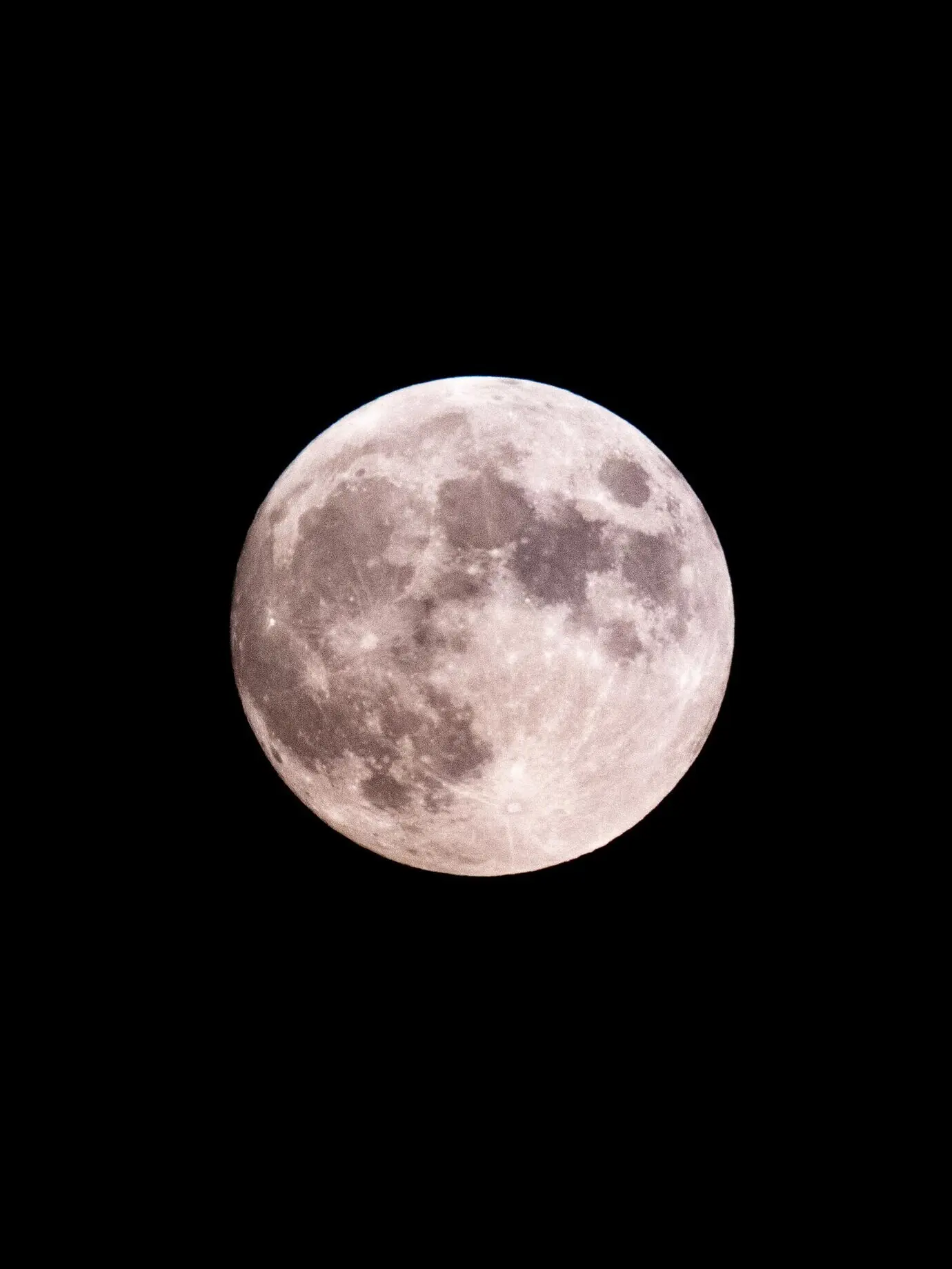 Close-up of a large full moon with craters visible along its edges.